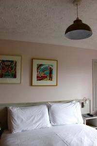 a bedroom with a bed with two pictures on the wall at Yaxham Mill in East Dereham