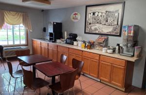 a restaurant with a table and chairs and a counter at Super 8 by Wyndham O'Fallon MO/St. Louis Area in O'Fallon