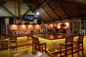 a bar in a restaurant with wooden tables and chairs at Uitkyk Guest Farm in Usakos