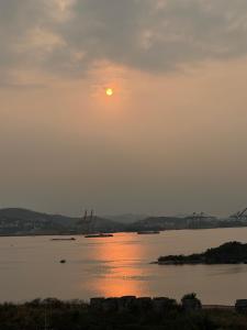 a sunset over the water with a bridge in the background at The Ruby Hạ Long in Ha Long