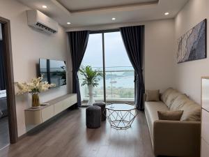 a living room with a couch and a large window at The Ruby Hạ Long in Ha Long