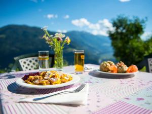 einen Tisch mit einem Teller mit Speisen und Getränken darauf in der Unterkunft Gasthaus Gasteiger in Algund