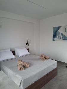 two beds in a white room with towels on them at Haraki Sunstone in Haraki