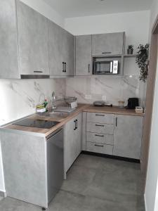a kitchen with a sink and a microwave at Haraki Sunstone in Haraki