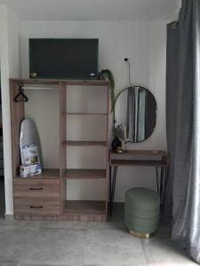 a room with a tv and a table and a mirror at Haraki Sunstone in Haraki