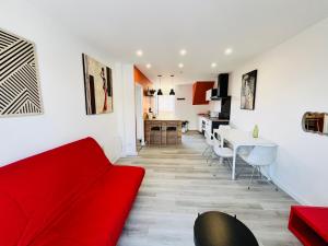 a living room with a red couch and a table at Le Vinois Climatisation 2 chambres balcon in Vinay