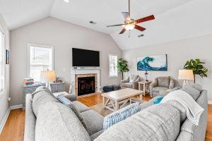 a living room with two couches and a tv at Rising Sun OBX in Corolla
