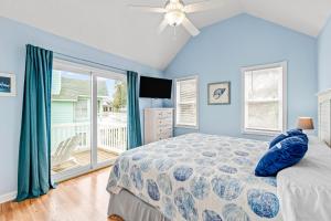 a bedroom with a bed and a large window at Rising Sun OBX in Corolla +51 photos