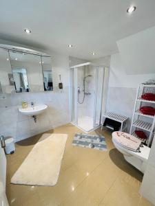 a bathroom with a shower and a toilet and a sink at Gästehaus Rosenkamp in Scharbeutz