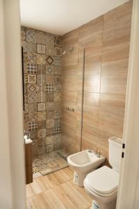 a bathroom with a toilet and a shower and a sink at Aires de Laguna in Chascomús +21 photos