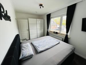 a small bedroom with a bed and a window at Haus Larum App. 3 in Scharbeutz