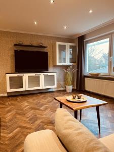 a living room with a couch and a tv at Haus Larum App. 6 in Scharbeutz