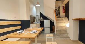 a kitchen with two wooden tables and a staircase at Nest Scilla in Scilla