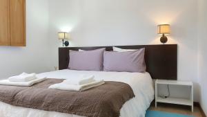 a bedroom with a bed with two towels on it at Casa do Mar - Lagoa de Óbidos, T3, piscina, vista lagoa in Vau +71 photos