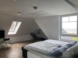 a bedroom with a bed and a window at Meersicht Haffkrug in Haffkrug