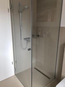 a shower stall with a glass door in a bathroom at Meersicht Haffkrug in Haffkrug +23 photos