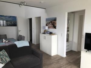 a living room with a couch and a television at Meersicht Haffkrug in Haffkrug