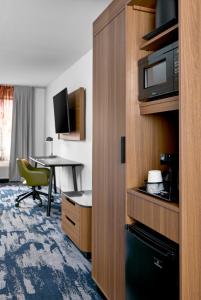 a hotel room with a desk and a microwave at Fairfield by Marriott Inn & Suites LaGrange in La Grange