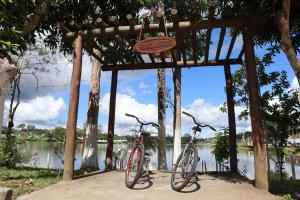 two bikes parked under a wooden structure next to a river at Pousada de Itajuípe em Itajuípe in Itajuípe