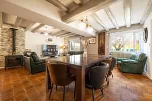 a living room with a wooden table and chairs at À 300m du virage de Mulsanne - Maison 8 pers avec extérieur et parking in Mulsanne