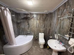 a bathroom with a tub and a toilet and a sink at Ayvon Guesthouse in Samarkand +19 photos