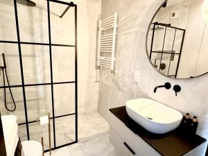 a bathroom with a sink and a mirror at Apartamant Oaza II in Koszalin