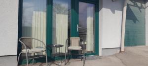 two chairs and a table in front of a door at Apartmani Ela 2 3 in Sierning