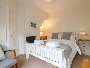 a bedroom with a white bed and a fireplace at Lumford Mill Cottage in Bakewell