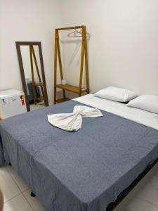 a bedroom with a bed with a towel on it at pousada palmeiras bhs in Barreirinhas