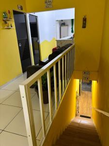 a room with a staircase with a yellow wall at pousada palmeiras bhs in Barreirinhas