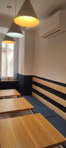 a room with wooden tables and benches and lights at Nest Scilla in Scilla