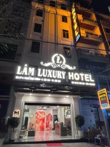 a lit up sign for a law luxury hotel at night at Lâm Luxury Hotel Lào Cai in Chơ Mơi