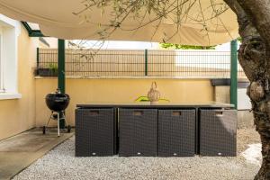 an outdoor table with a grill and an umbrella at À 300m du virage de Mulsanne - Maison 8 pers avec extérieur et parking in Mulsanne