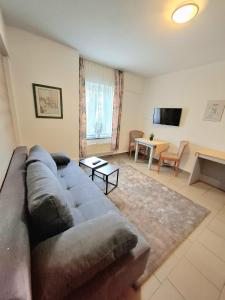 a living room with a couch and a table at Hotel Pappelhof in Weidenbach