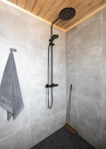 a shower in a bathroom with a tile wall at Tupa Lodge by The Guide Father in Rovaniemi