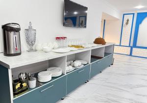 a kitchen with blue cabinets with plates and dishes at Amir Mumtoz Hotel in Bukhara