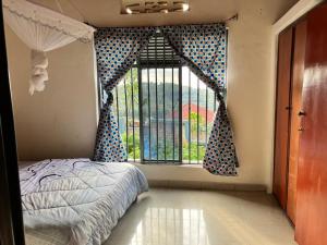 a bedroom with a bed and a large window at Bonnie's Homestay 