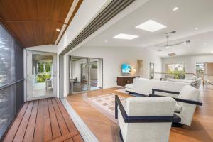 a living room with a white couch and chairs at Bentley Beach House in Sanibel