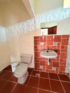 a bathroom with a toilet and a sink at Finca Hostal Ágora in Jardin +49 photos