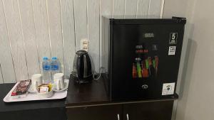 a black refrigerator sitting on top of a counter at Dya Hotel Boyolali in Boyolali