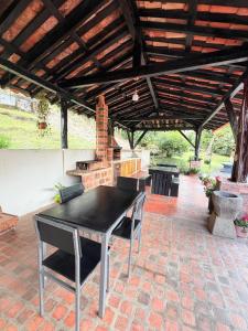 a patio with a black table and a fireplace at Finca Hostal Ágora in Jardin