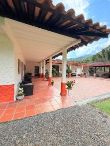an outdoor patio with awning and a brick floor at Finca Hostal Ágora in Jardin