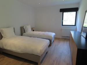 a room with two beds and a table and a window at Appartement 2 chambres Rochefort in Rochefort