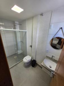 a bathroom with a toilet and a sink and a mirror at Apart Suítes Praia Do Morro 5 a 7 dias e Barato in Guarapari