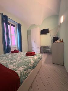 a bedroom with a bed with red pillows on it at b&b La Rosa dei venti in Alassio