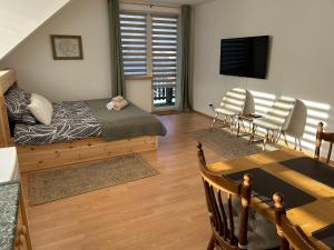 a bedroom with a bed and a table and chairs at Villa van Dam in Miłków