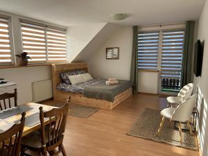 a bedroom with a bed and a table and chairs at Villa van Dam in Miłków