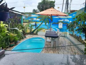 a table with an umbrella next to a swimming pool at Hospedagem Chapéu Virado in Belém