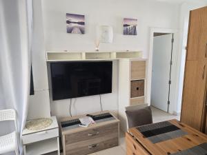 a living room with a flat screen tv on a wall at Maspalomas Lago Canary Sunset in Maspalomas