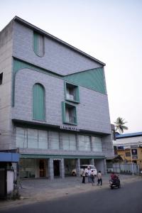 a group of people standing outside of a building at Hotel Bariz Perinthalmanna in Perintalmanna